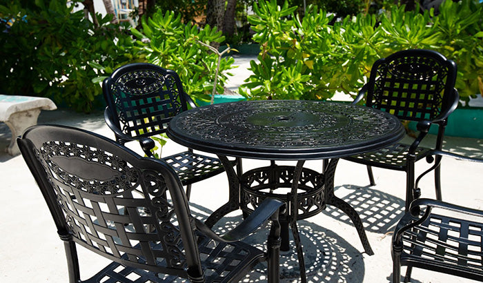 Black metal patio furniture set featuring chairs and a table, designed for outdoor use and protected with metal spray.